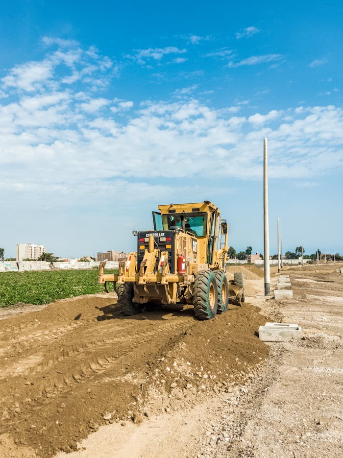Home A powerful tractor working on a construction site under a bright blue sky, highlighting heavy engineering equipment.